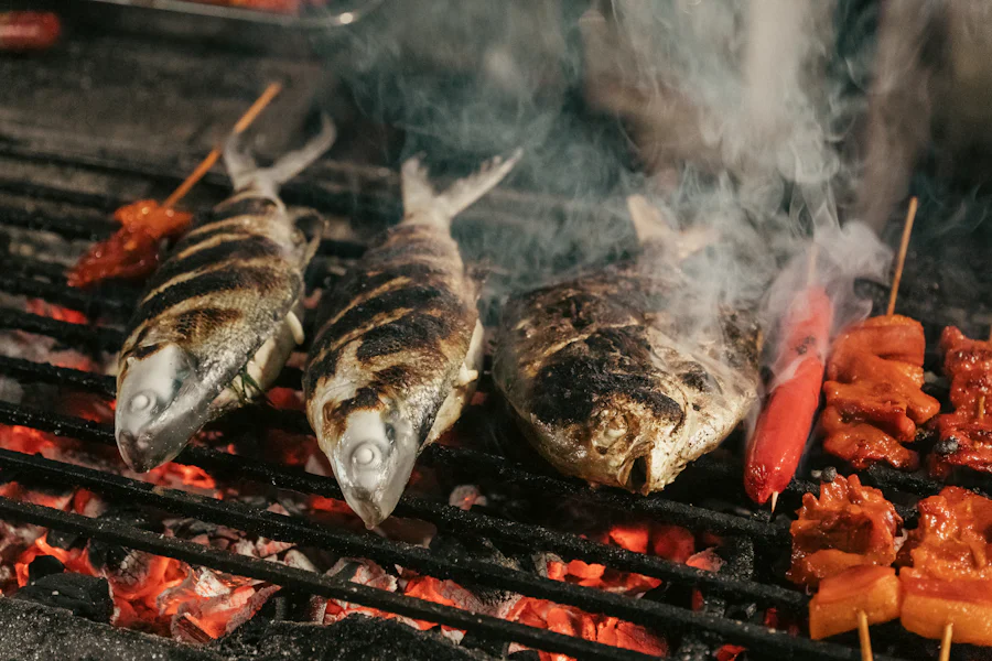 Kömür ateşinde, dumanı tüten ızgarada pişen bütün balıklar
