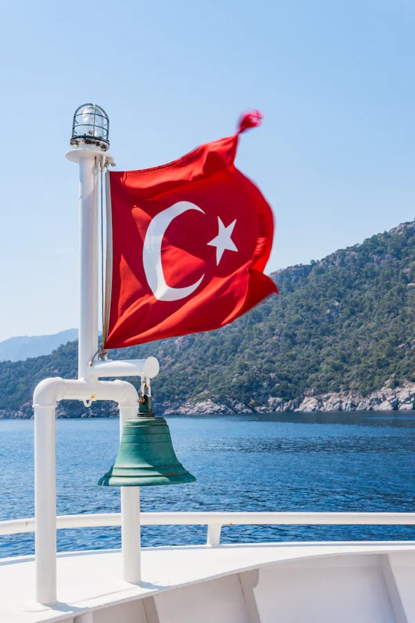 Teknenin kıç tarafında dalgalanan Türk bayrağı ve pirinç gemi çanı